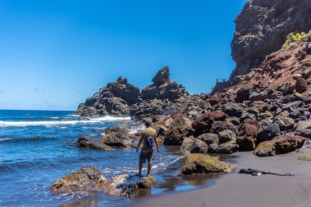 Playa de Nogales의 바위 위에서 바다로 여름을 즐기는 젊은 관광객