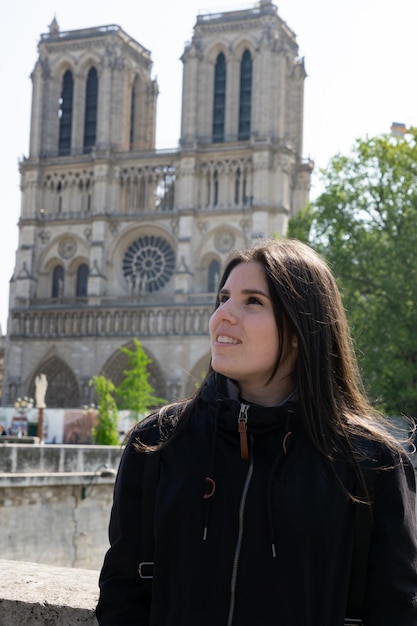 Foto giovane ragazza turistica presso la cattedrale di notre dome a parigi