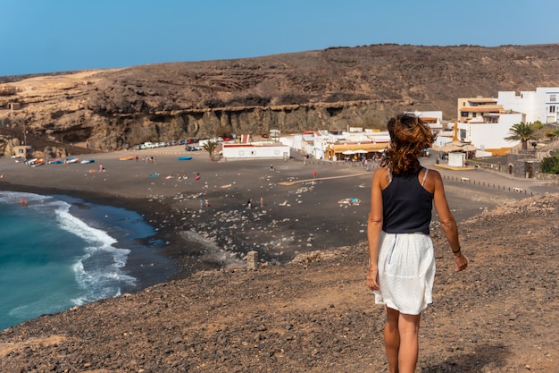 A young tourist girl on vacation on the beach of Ajuy, Pajara, west coast of the island of Fuerteventura, Canary Islands. Spain