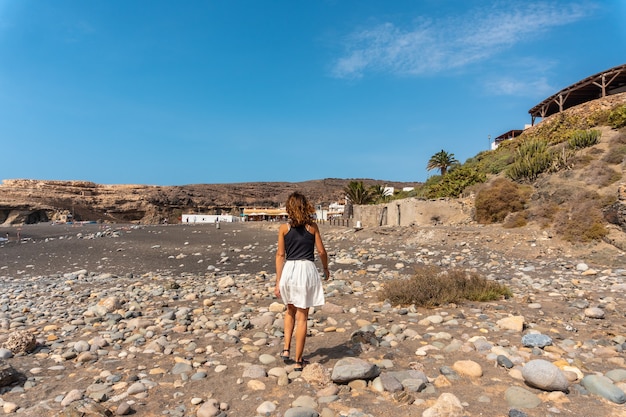 A young tourist girl on vacation on the beach of Ajuy, Pajara, west coast of the island of Fuerteventura, Canary Islands. Spain