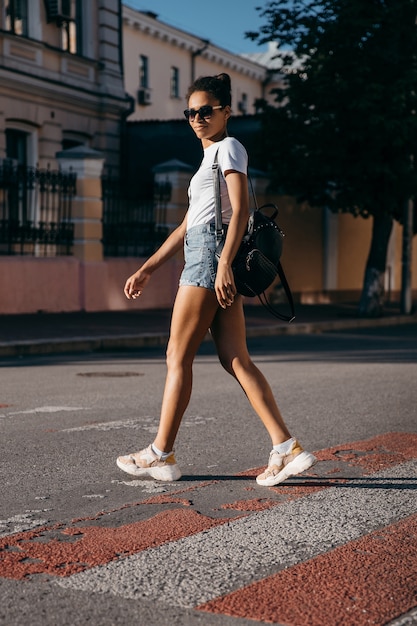 Ragazza giovane turista che cammina sulla strada