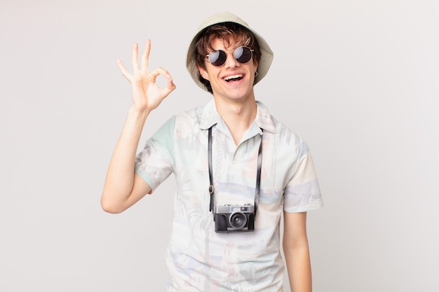 Young tourist man feeling happy, showing approval with okay gesture