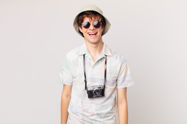 Young tourist man looking happy and pleasantly surprised