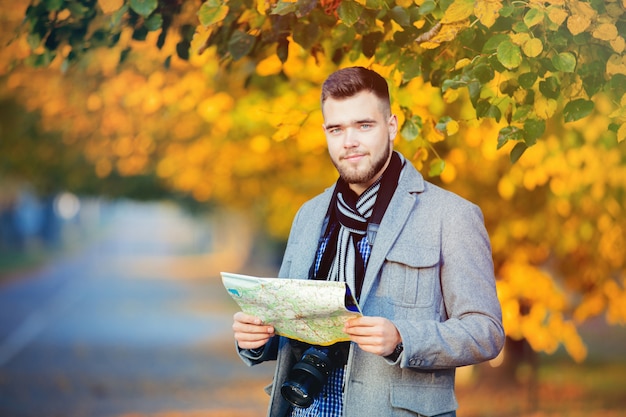 Young tourist man with map and camera