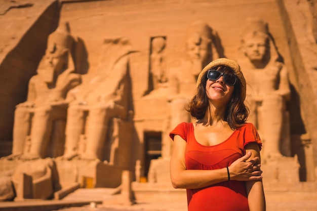 A young tourist in red dress at the Abu Simbel Temple in southern Egypt in Nubia