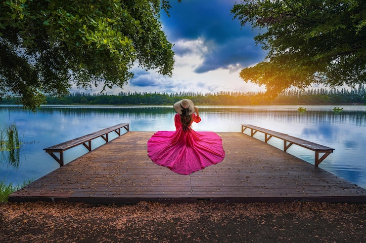 Photo young tourist sitting on nong han pier near the lotus garden in sakon nakhon provincethailand