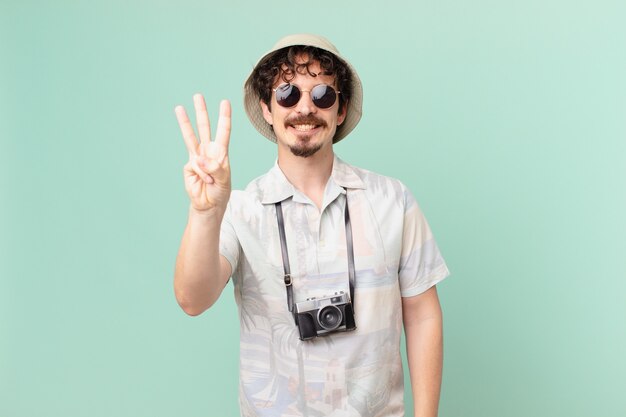 Young tourist smiling and looking friendly, showing number three