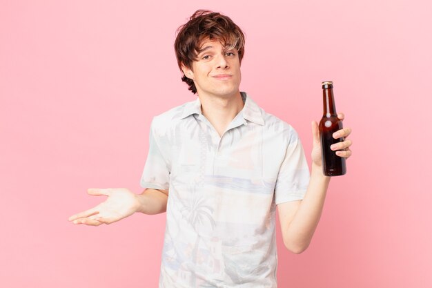 Young tourist with a beer shrugging feeling confused and uncertain