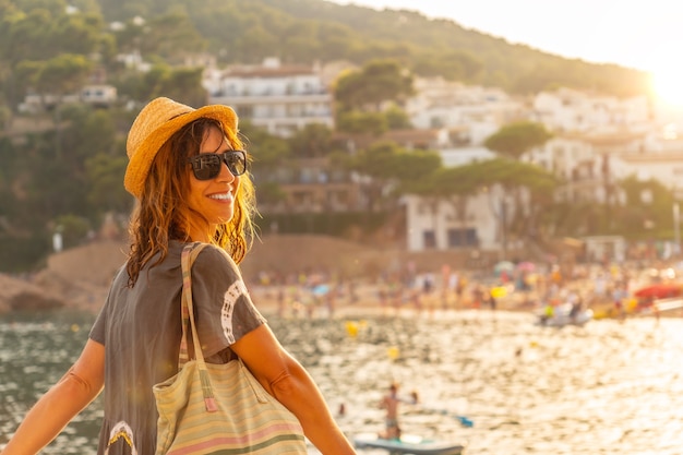 A young tourist with a hat at sunset on the coast of Tamariu in the town of Palafrugell. Girona, Costa Brava in the Mediterranean