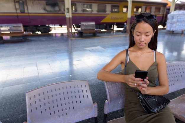 Foto giovane donna turistica che esplora la città di bangkok alla stazione ferroviaria