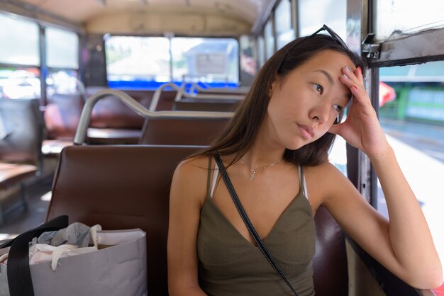 Young tourist woman exploring the city of Bangkok with bus