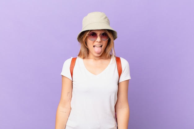 Young tourist woman feeling disgusted and irritated and tongue out