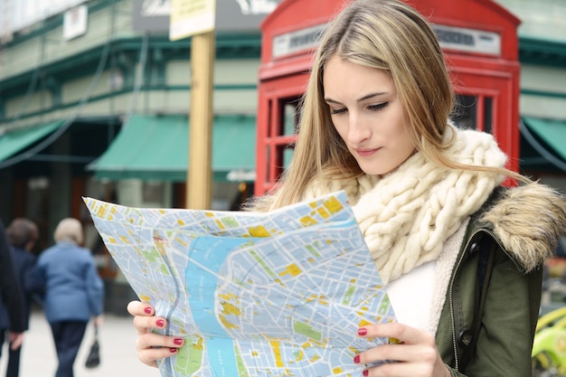 Young tourist woman looking at a map.