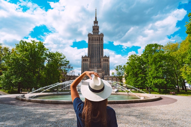 Young tourist woman in white sun hat walking in the park in Warsaw city Poland