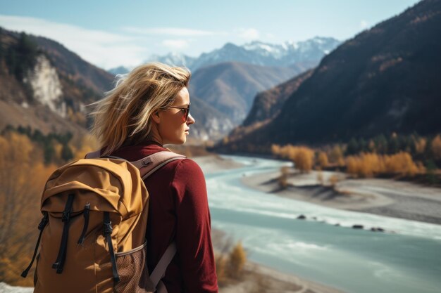 Photo young tourist woman with a large backpack looks at the lake and mountains