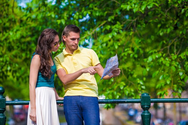 Young tourists couple looking at map in european city