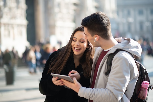 Young tourists couple using a digital tablet in a city