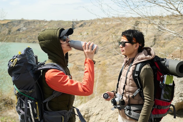 Young tourists drinking tea or water