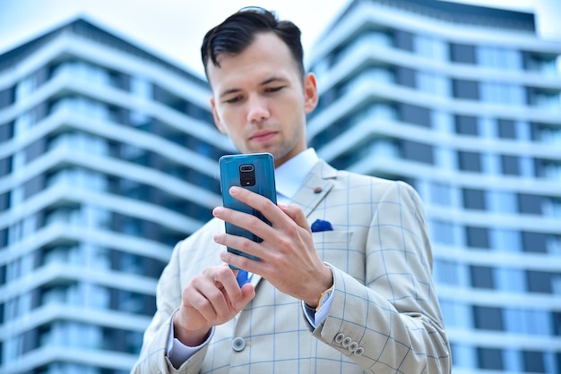 Young trader man in suit using smart phone