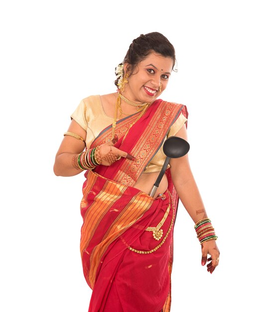 Young Traditional Indian Girl holding kitchen utensil on white