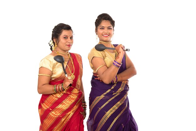 Young Traditional Indian Girls holding kitchen utensil on white