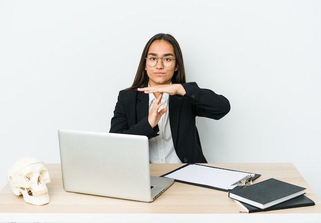 Young traumatologist asian woman isolated on white wall showing a timeout gesture.