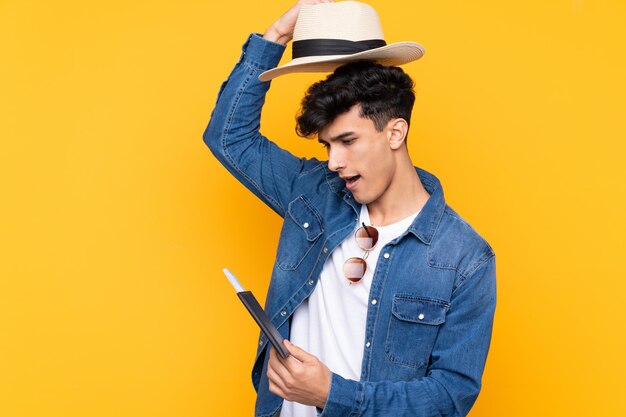 Young traveler man over isolated wall