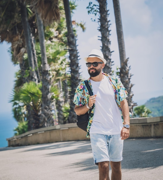 Young traveler man at summer holiday vacation with beautiful palms and seascapes at background