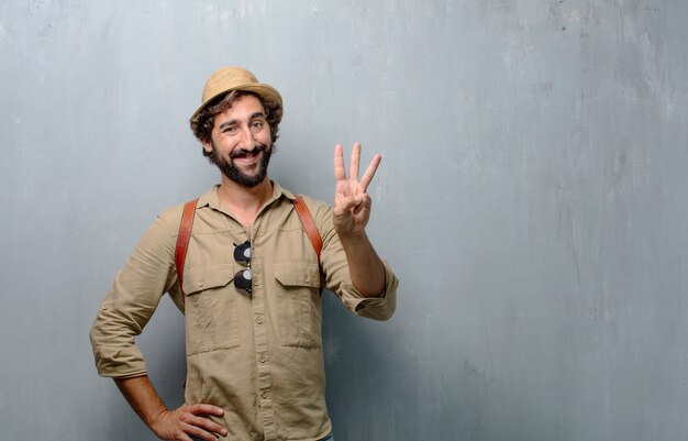 Young traveler man or tourist smiling , counting number three with fingers.