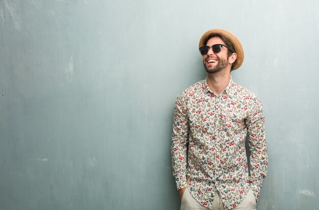 Young traveler man wearing a colorful shirt laughing and having fun