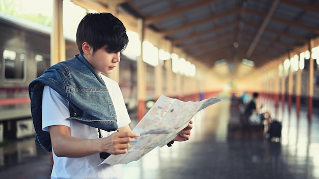 Young traveler reading a map in train station