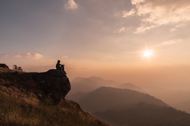 Photo young traveler relaxing and looking beautiful landscape on top of mountain, adventure travel lifestyle concept