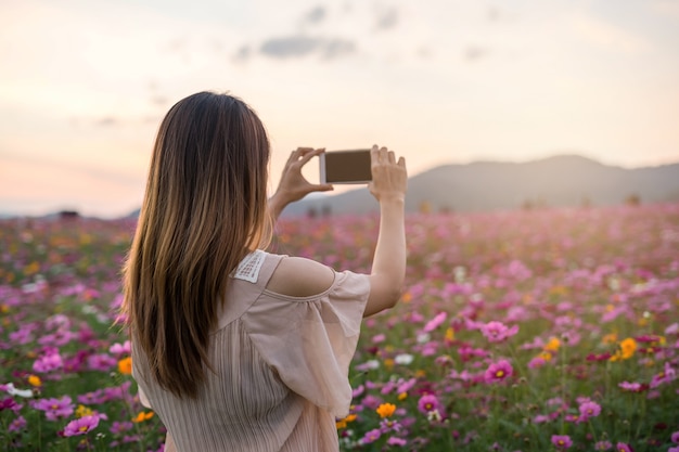 Giovane viaggiatore che cattura i fiori di fioritura della foto