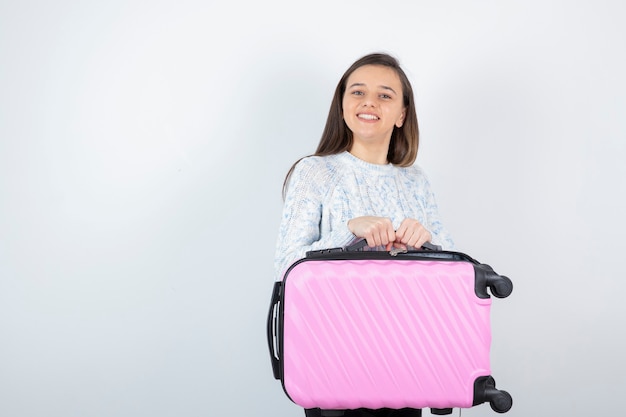 young traveler tourist holds pink suitcase and waiting for her pass. 