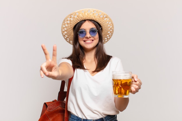 Young traveler woman celebrating successful a victory and holding a beer