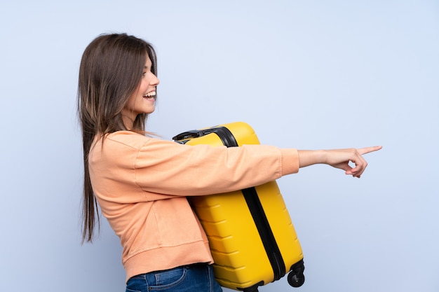 Young traveler woman over isolated wall