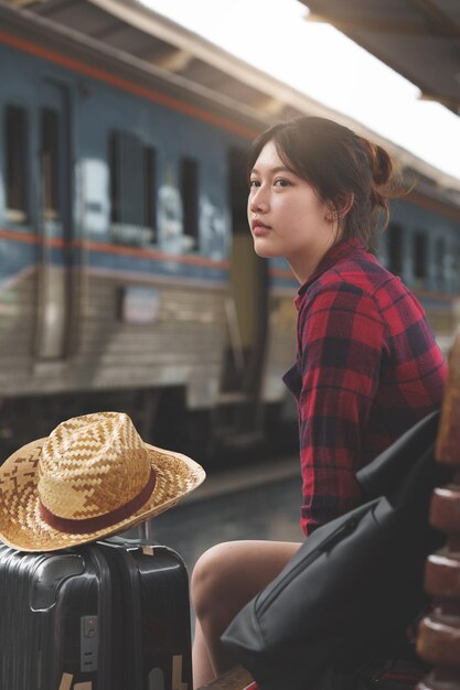 Young traveler woman looking for friend planning trip at train\
station summer and travel lifestyle concept