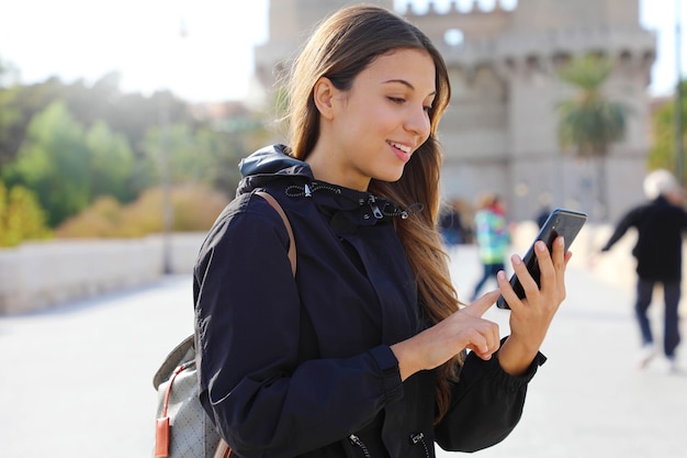 Young traveler woman using application map on smartphone