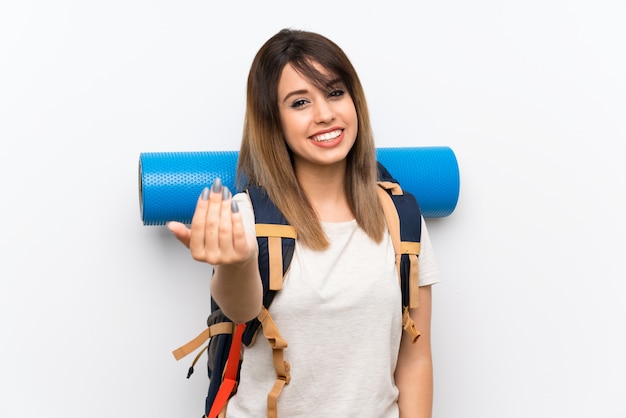 Young traveler woman over white inviting to come with hand. Happy that you came