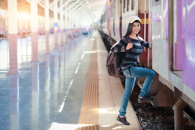 Young traveler woman with backpack getting on the train