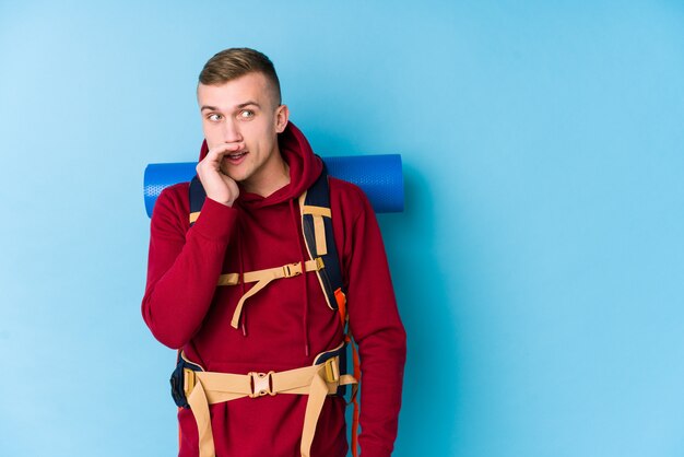 Young traveller caucasian man is saying a secret hot braking news and looking aside