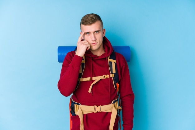 Young traveller caucasian man pointing temple with finger, thinking, focused on a task.