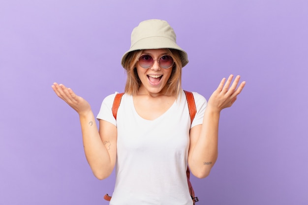 Young traveller tourist woman feeling happy and astonished at something unbelievable