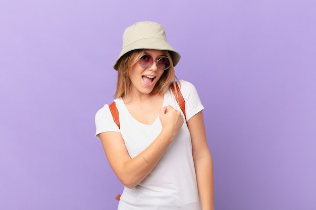 Photo young traveller tourist woman feeling happy and facing a challenge or celebrating