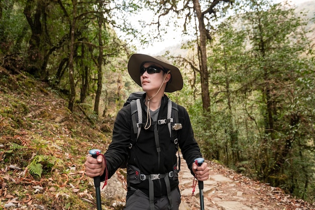 Un giovane viaggiatore che fa trekking sul sentiero forestale nepal