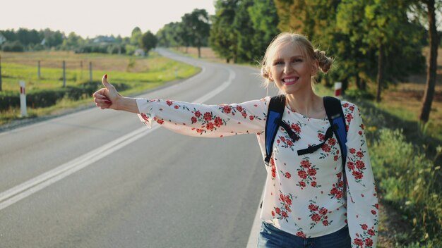 若い旅行女性はバックパックで家を出ます。