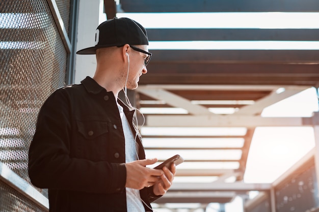 A young trendy hipster guy in a black glasses cap