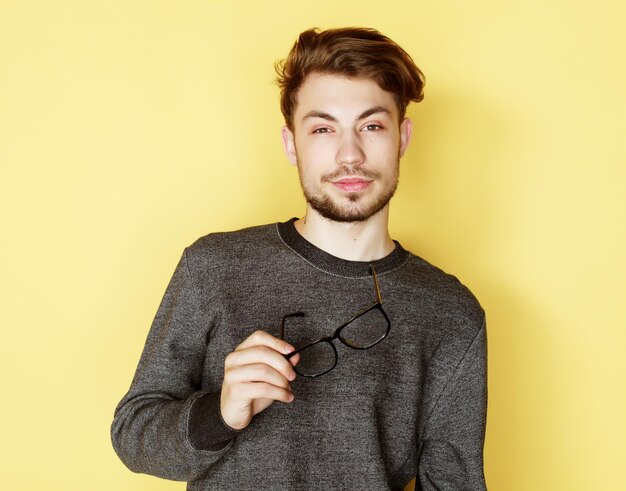 Young trendy man with glasses smiling studio shot