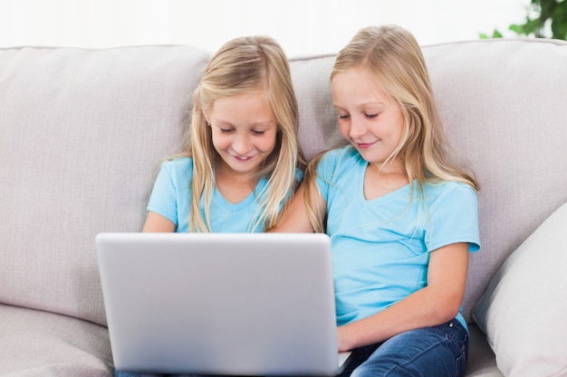 Young twins using a laptop together