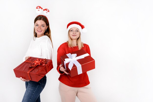 사진 크리스마스 컬러 스타일의 선물 상자를 들고 있는 두 명의 아름다운 젊은 여성